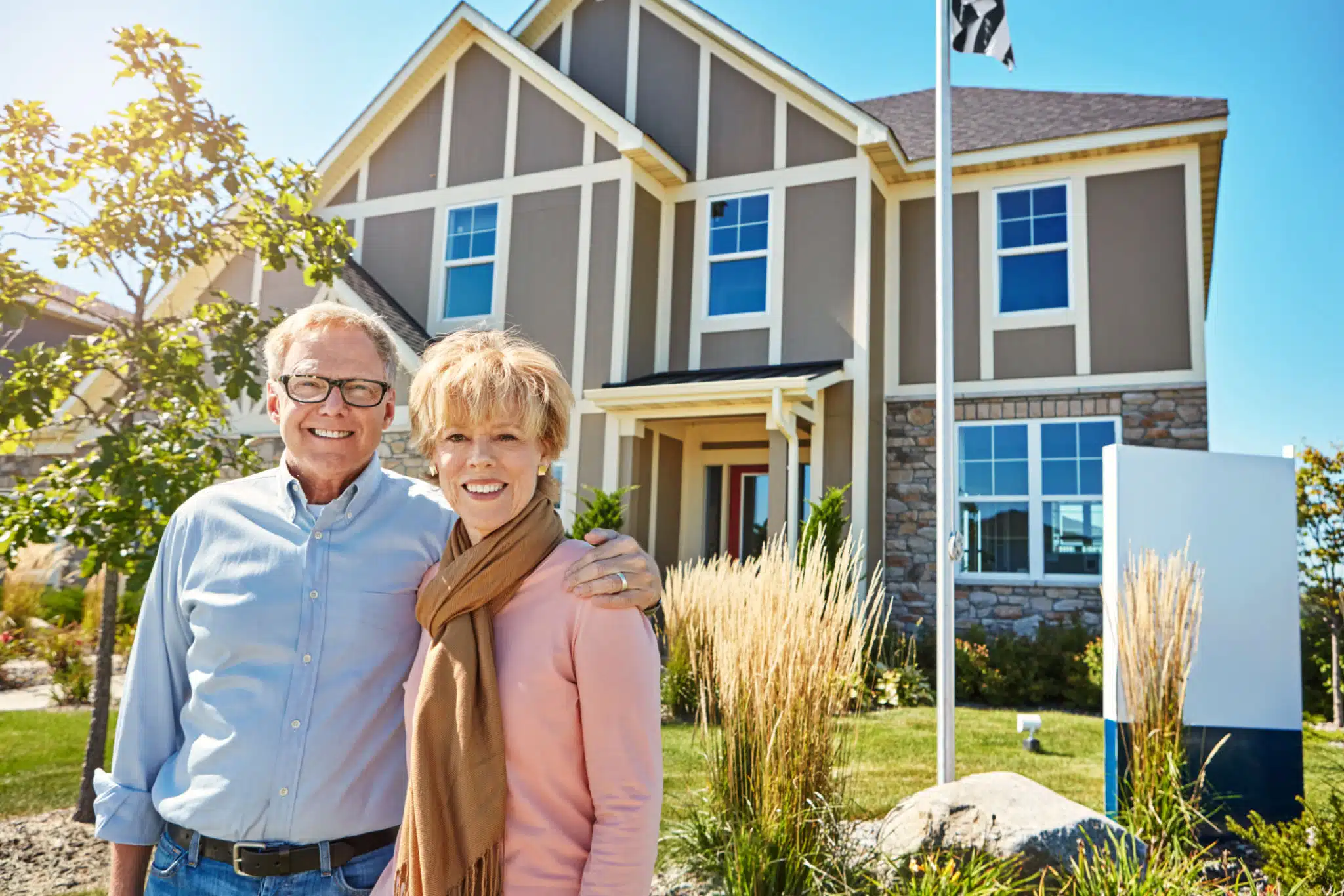 portrait of a happy senior couple posing outside their new home